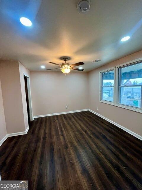 empty room with dark hardwood / wood-style flooring and ceiling fan