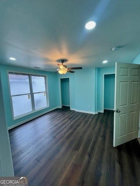 empty room featuring dark wood-type flooring and ceiling fan