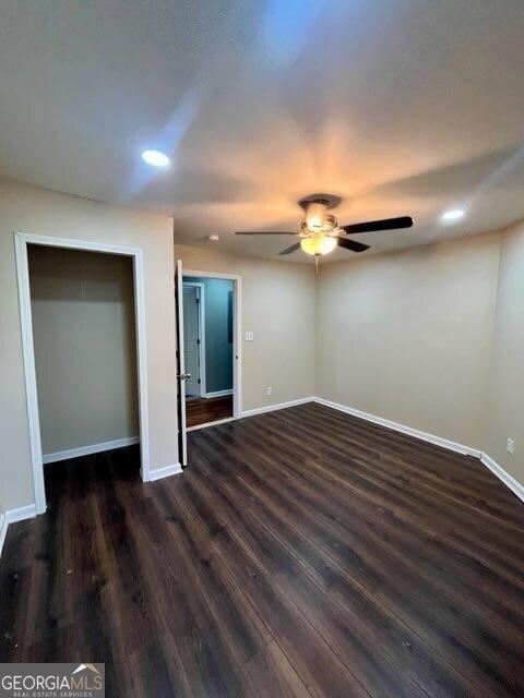 empty room with dark hardwood / wood-style floors and ceiling fan