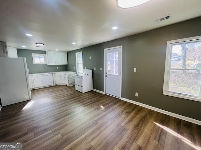 kitchen with white cabinetry, white appliances, and hardwood / wood-style flooring