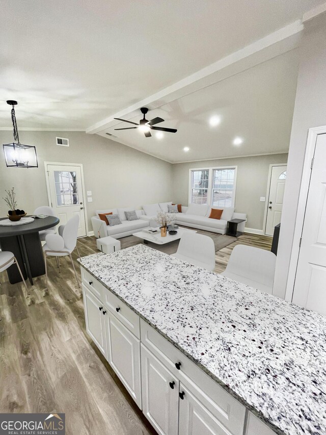 kitchen featuring lofted ceiling, sink, white cabinetry, appliances with stainless steel finishes, and light hardwood / wood-style floors