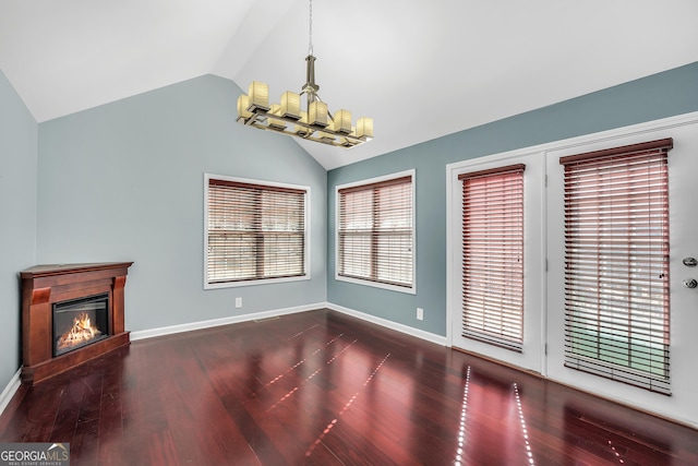 interior space with vaulted ceiling, dark hardwood / wood-style floors, and an inviting chandelier