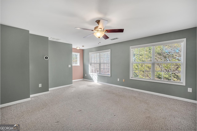 spare room featuring plenty of natural light, carpet flooring, and ceiling fan