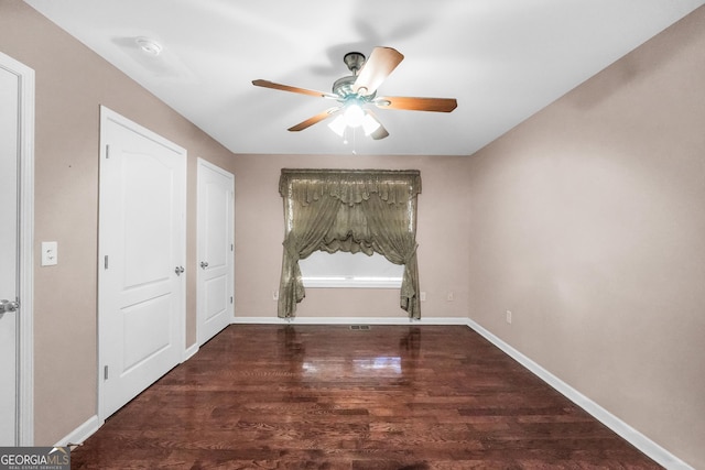 unfurnished room with dark wood-type flooring and ceiling fan