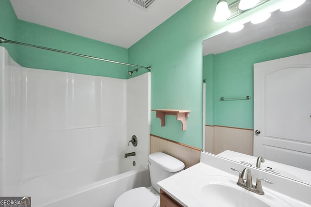 full bathroom featuring vanity, wooden walls, bathtub / shower combination, and toilet