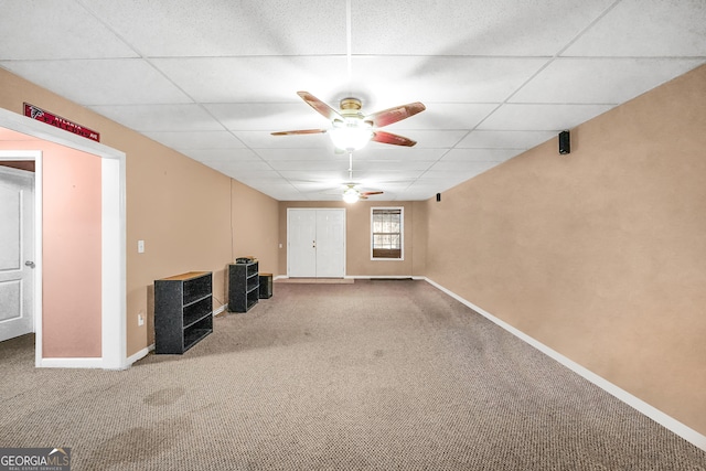 interior space with ceiling fan, a paneled ceiling, and carpet floors