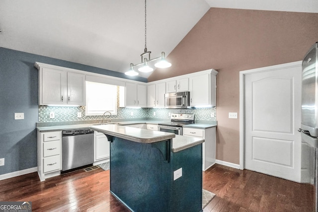 kitchen featuring pendant lighting, appliances with stainless steel finishes, white cabinetry, high vaulted ceiling, and a kitchen island