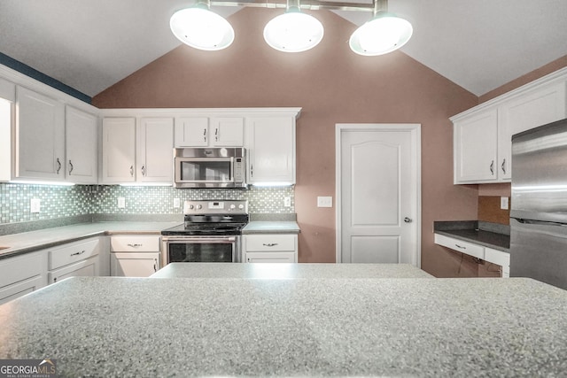 kitchen with white cabinetry, lofted ceiling, stainless steel appliances, and decorative light fixtures