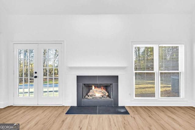 unfurnished living room with wood-type flooring and french doors