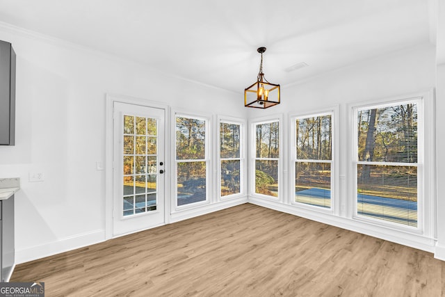 unfurnished sunroom featuring a notable chandelier and plenty of natural light