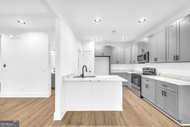 kitchen featuring stainless steel appliances, sink, gray cabinetry, and light wood-type flooring