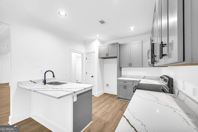 kitchen with light stone counters, sink, stainless steel range with electric cooktop, and gray cabinetry