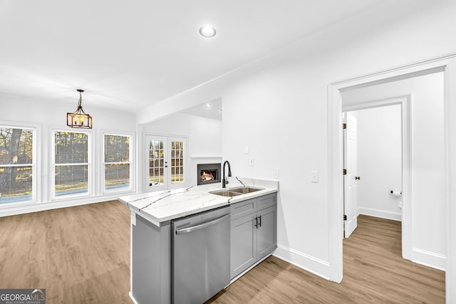 kitchen with sink, gray cabinets, hanging light fixtures, light stone countertops, and stainless steel dishwasher