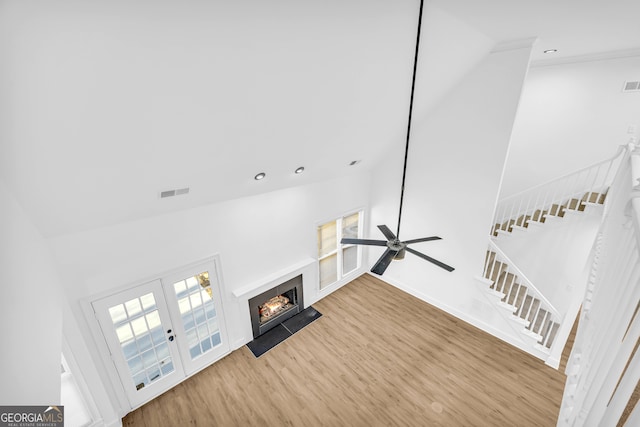 unfurnished living room with french doors, ceiling fan, wood-type flooring, and vaulted ceiling