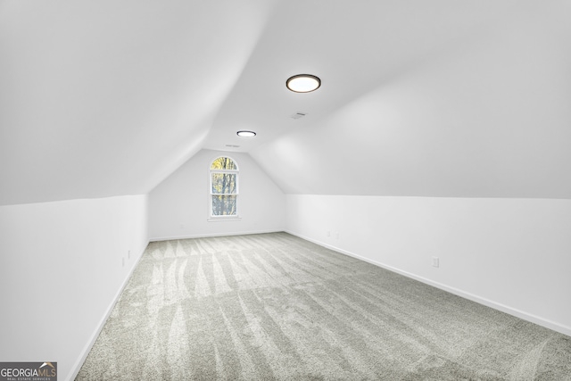 additional living space with vaulted ceiling and carpet floors