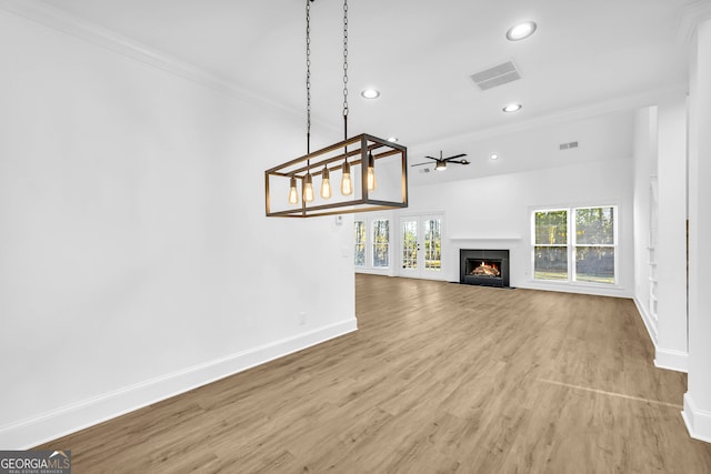 unfurnished living room featuring ornamental molding and wood-type flooring