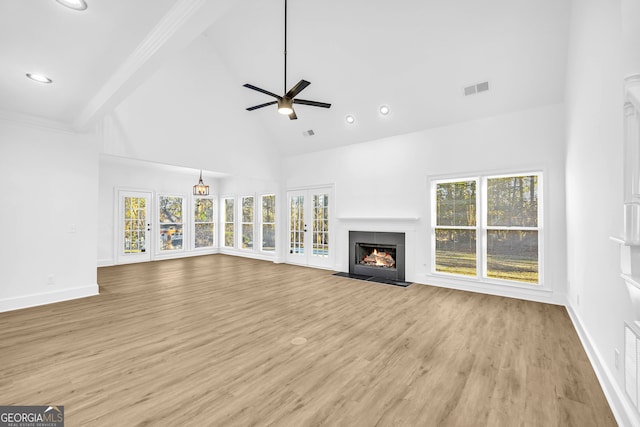 unfurnished living room with beamed ceiling, ceiling fan, high vaulted ceiling, and light hardwood / wood-style flooring