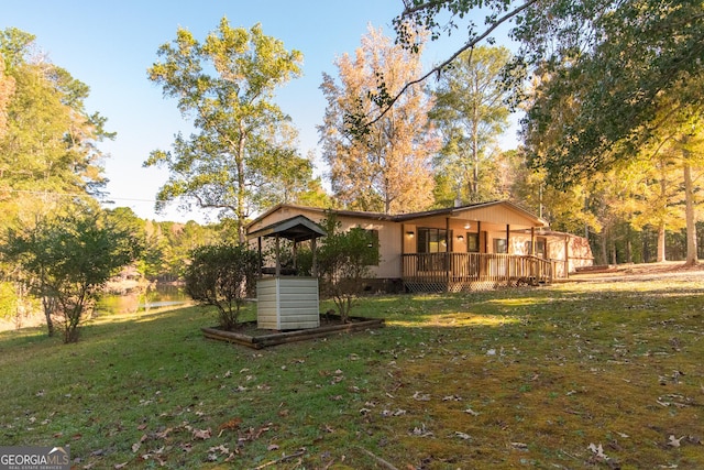 view of front of house with a deck and a front lawn