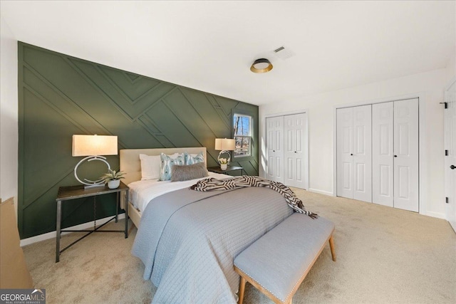 bedroom with two closets and light carpet