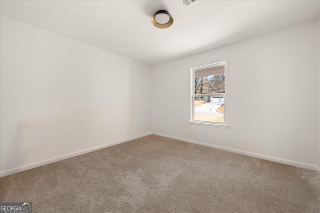 carpeted empty room featuring a textured ceiling