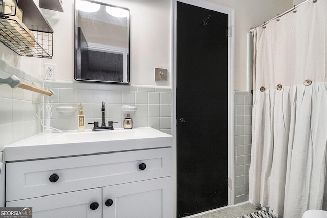 bathroom featuring vanity and tile walls