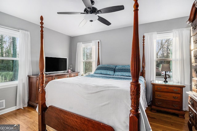 bedroom with dark hardwood / wood-style flooring and ceiling fan