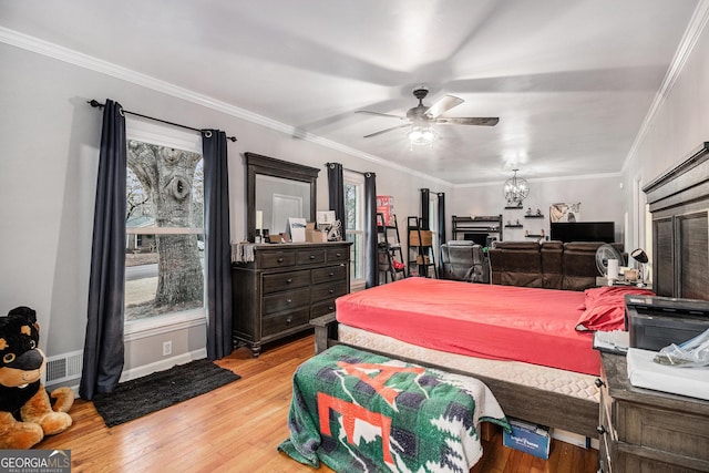 bedroom featuring multiple windows, ornamental molding, and light hardwood / wood-style floors