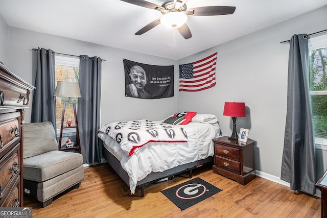 bedroom with multiple windows, ceiling fan, and light wood-type flooring