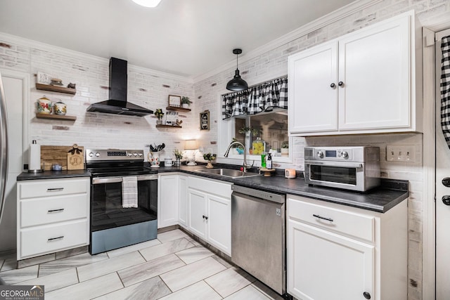 kitchen with wall chimney exhaust hood, sink, white cabinetry, appliances with stainless steel finishes, and pendant lighting