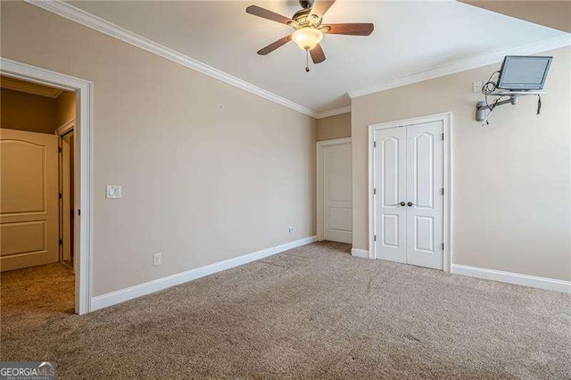 unfurnished bedroom with ornamental molding, carpet flooring, ceiling fan, and a closet