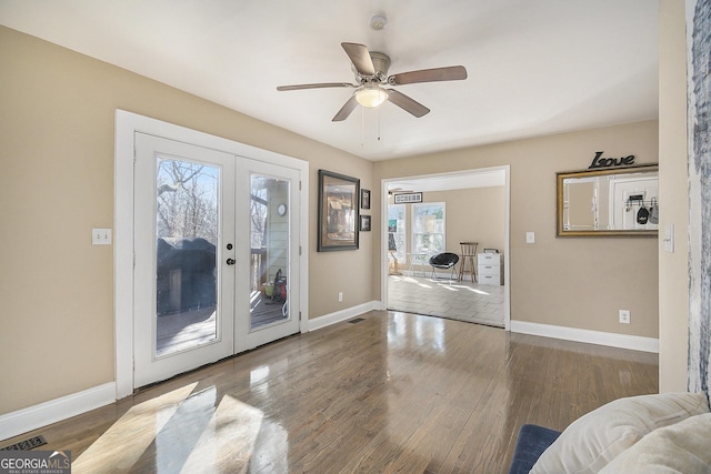 interior space with dark hardwood / wood-style floors, french doors, and ceiling fan