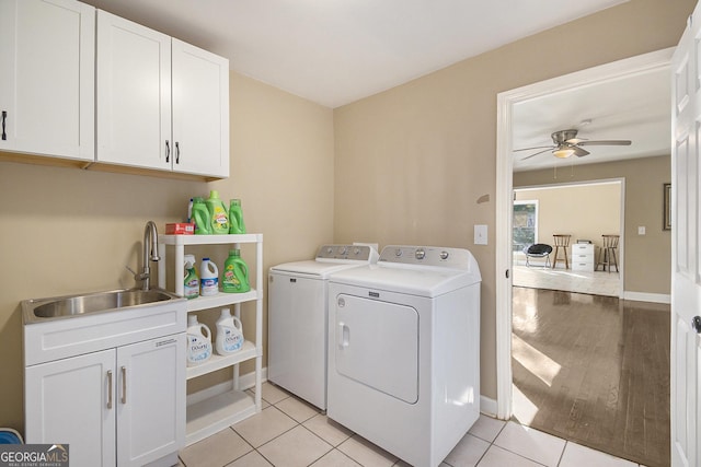 clothes washing area featuring sink, light tile patterned floors, ceiling fan, cabinets, and washing machine and clothes dryer