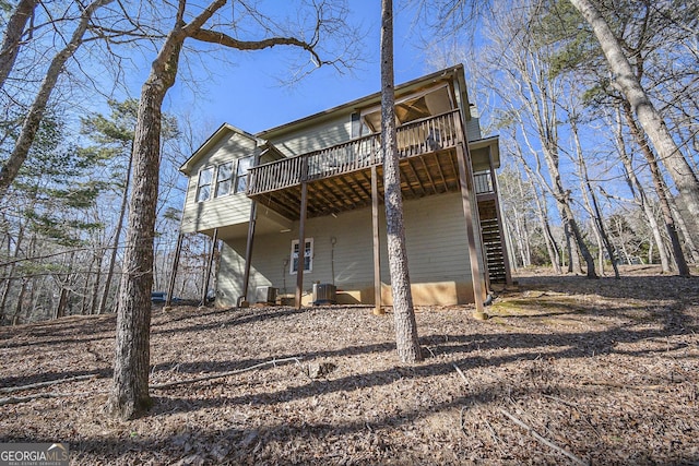 back of house featuring central AC unit and a wooden deck