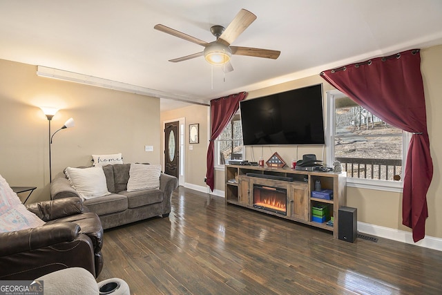 living room featuring ceiling fan and dark hardwood / wood-style flooring