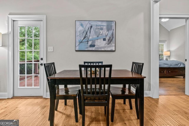 dining room with lofted ceiling and light hardwood / wood-style flooring