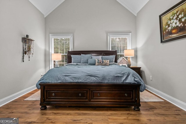 bedroom with vaulted ceiling, ornamental molding, and hardwood / wood-style floors