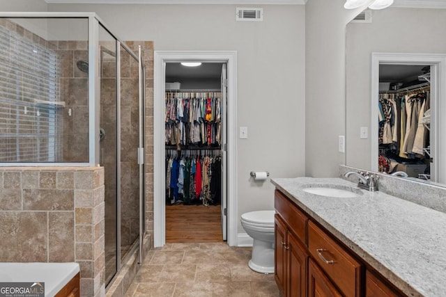 bathroom with vanity, toilet, and a shower with shower door