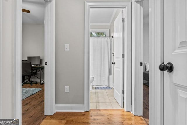 hallway with ornamental molding and light wood-type flooring