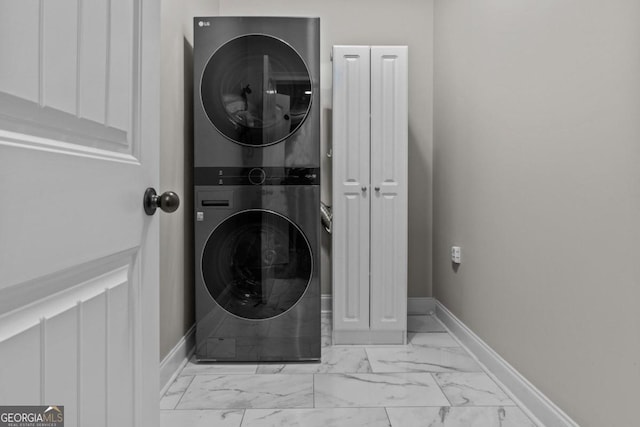 laundry room with cabinets and stacked washer and clothes dryer