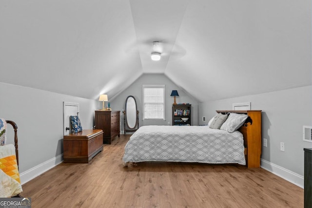 bedroom featuring vaulted ceiling and light wood-type flooring