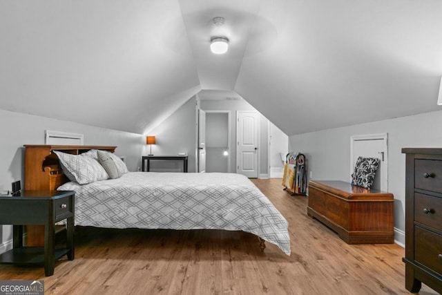 bedroom featuring lofted ceiling and light hardwood / wood-style floors