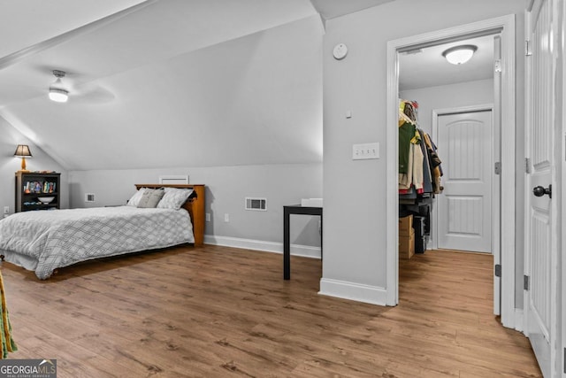 bedroom featuring wood-type flooring, a closet, ceiling fan, and vaulted ceiling