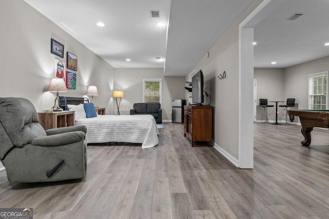 bedroom featuring billiards, stainless steel fridge, light hardwood / wood-style floors, and multiple windows