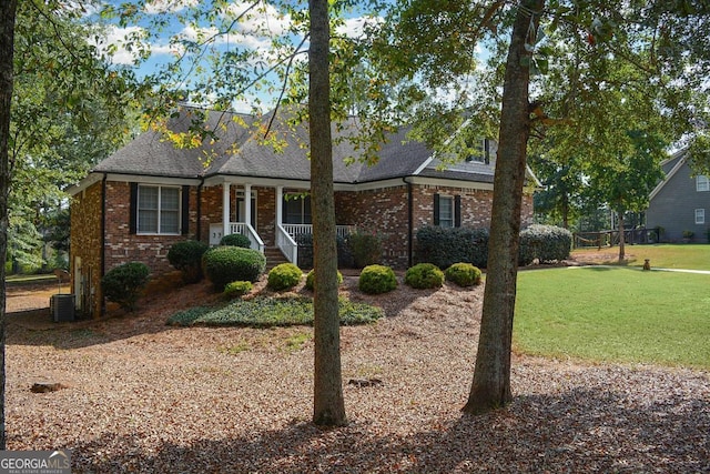 view of front of home with central AC, covered porch, and a front yard