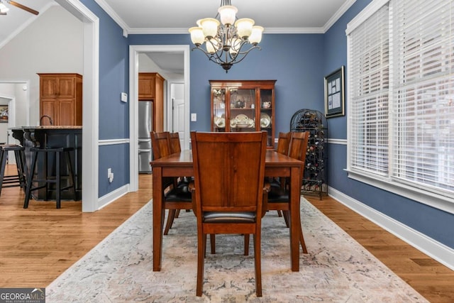 dining room featuring crown molding, a notable chandelier, and light wood-type flooring