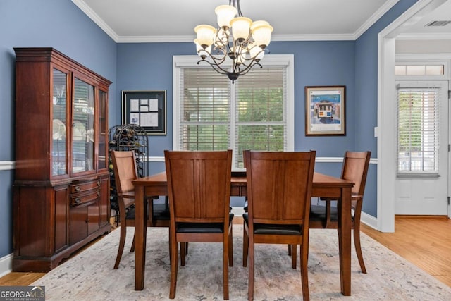 dining space with crown molding, a chandelier, and light hardwood / wood-style floors