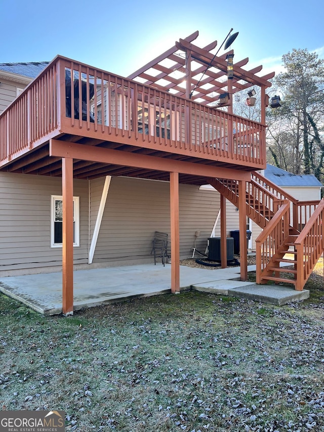 exterior space featuring central AC unit, a yard, a deck, and a patio