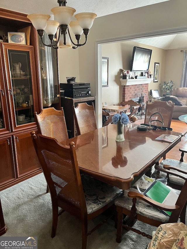 carpeted dining area with a notable chandelier and a fireplace