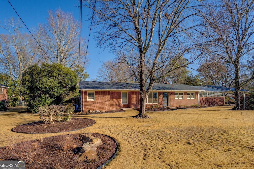 ranch-style home featuring a front lawn