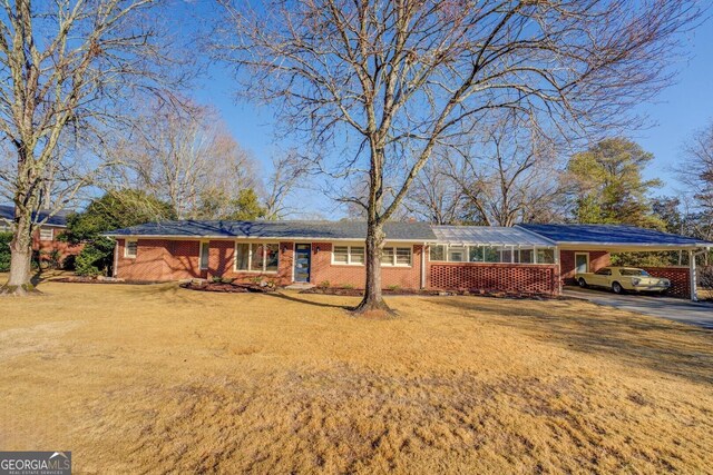 ranch-style house with a carport and a front yard